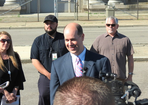 Matthew Moroun in a dark suit and striped tie outside Michigan Central Station.