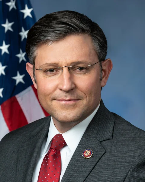 Official congressional portrait of Mike Johnson in a dark suit before a United States flag.